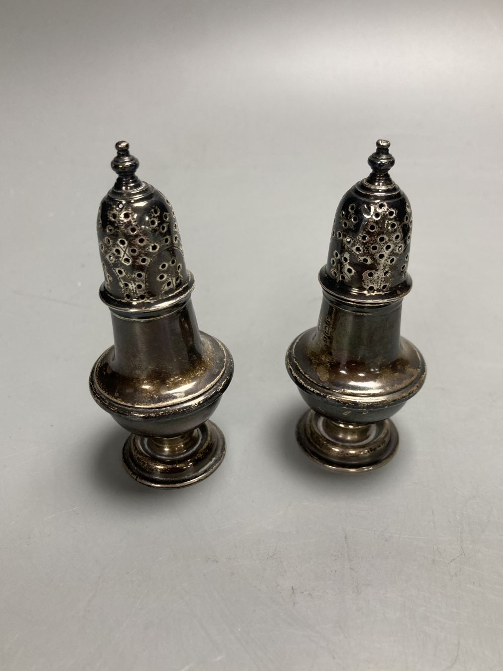 A pair of oval silver salts and spoons (cased), a butter knife and preserve spoon (cased), two pepperettes & a silver cigarette case